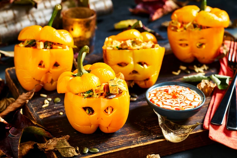 Four yellow peppers carved like jack-o-lanterns and stuffed with wild rice, vegetables, and diced Quorn Cocktail Sausages.
