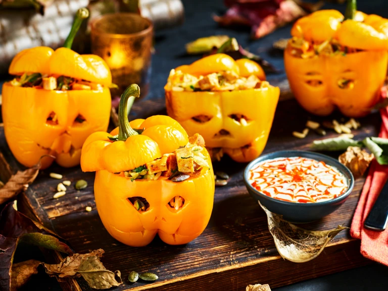 Four yellow peppers carved like jack-o-lanterns and stuffed with wild rice, vegetables, and diced Quorn Cocktail Sausages.