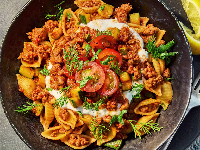 Vegetarian Turkish Pasta with Quorn Mince, courgette, cherry tomatoes, yoghurt, herbs and lemon served over shell pasta.