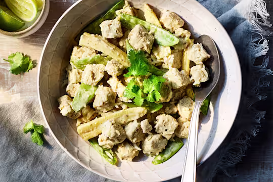 Easy Vegetarian Thai green curry served in a bowl, topped with mint with lime on the side.