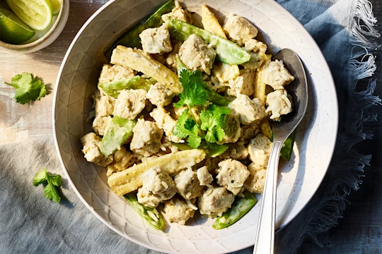 Easy Vegetarian Thai green curry served in a bowl, topped with mint with lime on the side.
