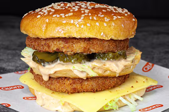 A double layered vegetarian chicken sits on Quorn branded paper