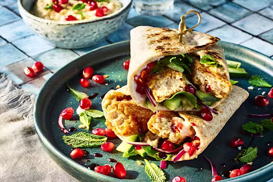 Vegetarian Turkish Wraps with Quorn Salt and Pepper Tenders served on a blue plate with pomegranate seeds