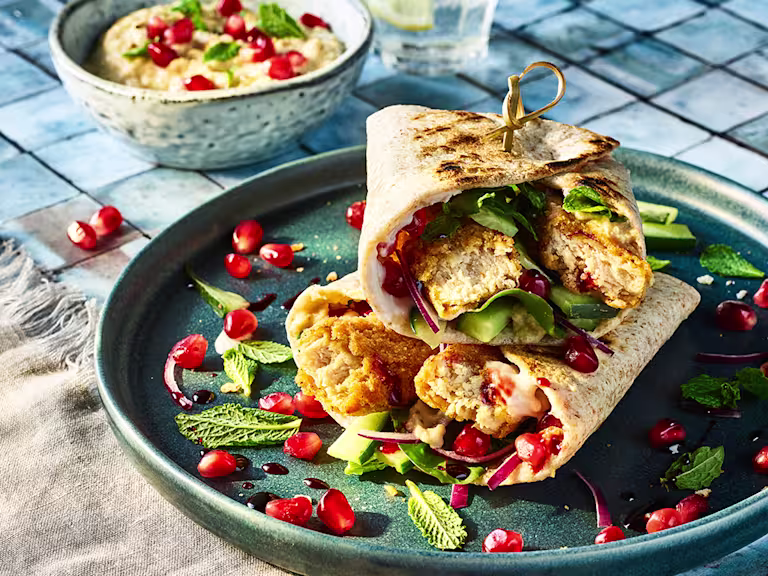 Vegetarian Turkish Wraps with Quorn Salt and Pepper Tenders served on a blue plate with pomegranate seeds