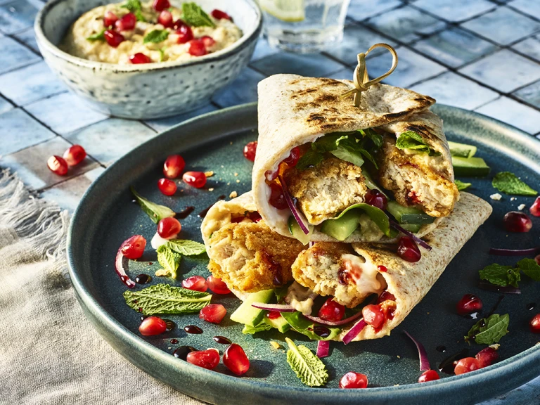 Vegetarian Turkish Wraps with Quorn Salt and Pepper Tenders served on a blue plate with pomegranate seeds
