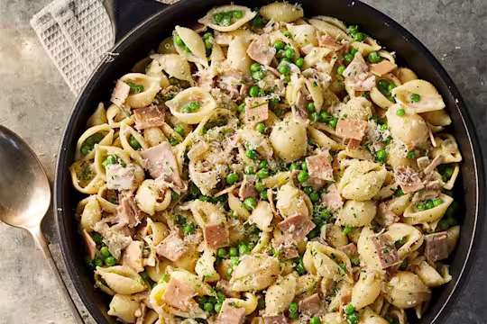 A large portion of Creamy Quorn Vegan Smoky Ham Style slices and Pea Vegan Pasta served in a dark dish.