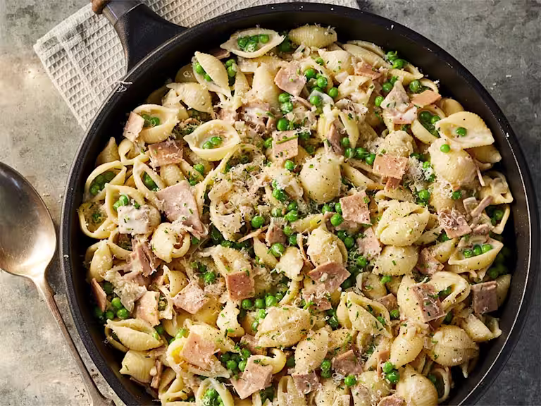 A large portion of Creamy Quorn Vegan Smoky Ham Style slices and Pea Vegan Pasta served in a dark dish.