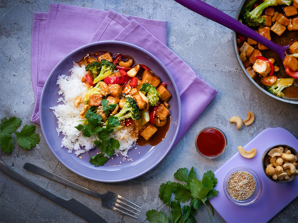Lautasellinen Sticky Quorn Kuutioita makean tulisessa sriracha- ja limekastikkeessa. Päällä parsakaalia ja punaista paprikaa. Tarjoillaan riisin kera.