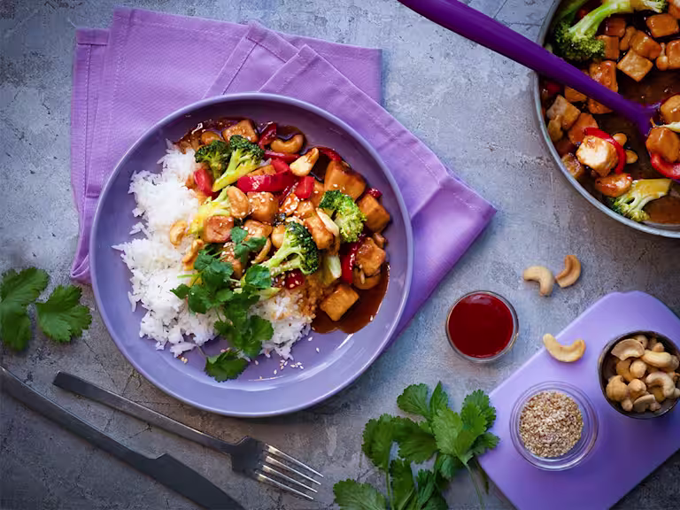 Lautasellinen Sticky Quorn Kuutioita makean tulisessa sriracha- ja limekastikkeessa. Päällä parsakaalia ja punaista paprikaa. Tarjoillaan riisin kera.