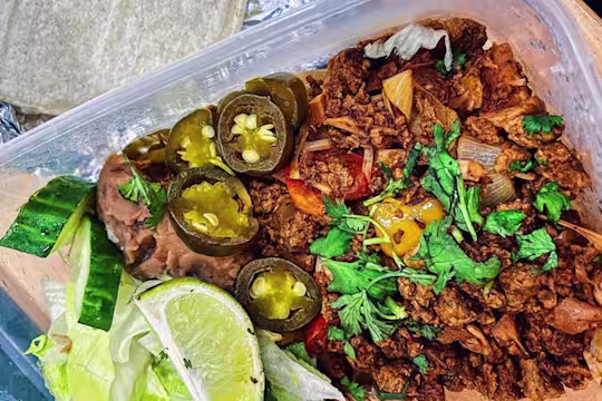 Quorn Vegetarian Mince and jackfruit mix in Tupperware with jalapenos, salad and fresh coriander.