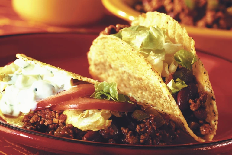 Veggie tacos recipe made with Quorn Mince chilli, lettuce, tomato, kidney beans and Greek yoghurt served on a plate
