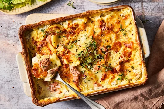 Vegetarian gratin with Quorn Ham Roast in a serving dish with serving spoon.