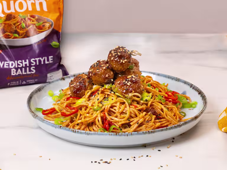 Sesame Glazed Quorn Swedish Meatballs served on top of a bed of chilli noodles.