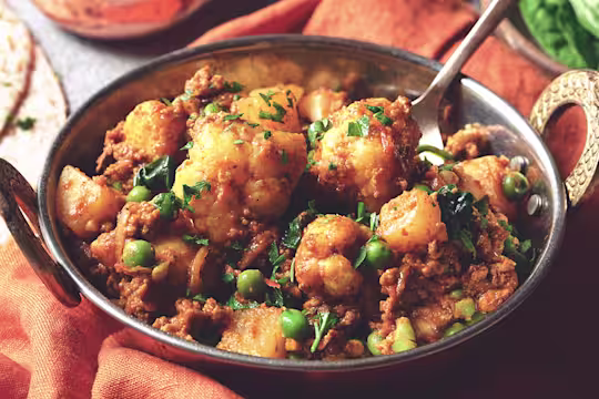 A serving bowl containing a recipe of Easy Quorn Mince & Madras Curry sat beside two servings of chapatti bread.