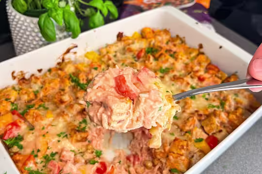 En ugnsform med krämig vegetarisk risgratäng, toppad med Quorn Bitar, paprika och jordnötter