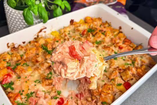 En ugnsform med krämig vegetarisk risgratäng, toppad med Quorn Bitar, paprika och jordnötter
