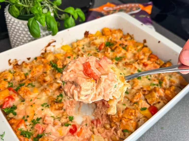 En ugnsform med krämig vegetarisk risgratäng, toppad med Quorn Bitar, paprika och jordnötter