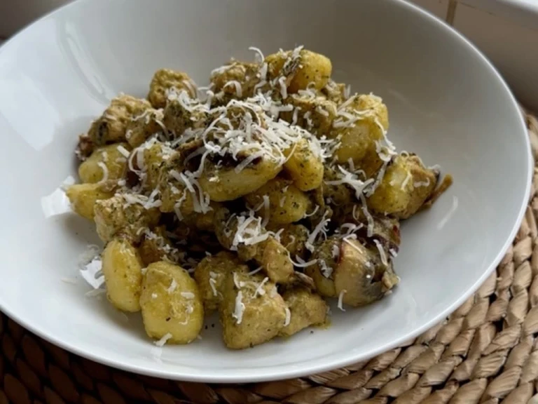Creamy pesto gnocchi with Quorn Pieces in a bowl topped with parmesan cheese.