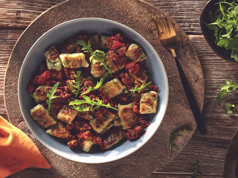 Vegetarian Gnocchi with a Quorn Mince Ragu, made with Quorn Mince, tomato, red wine, onion, garlic and cinnamon, served in a bowl.