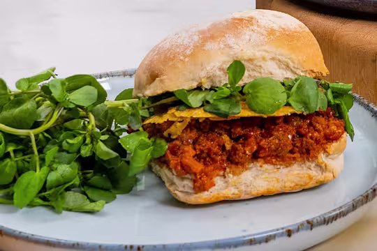 Three Quorn sloppy joes served alongside greens.