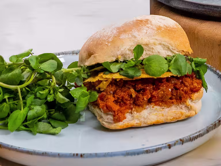 Three Quorn sloppy joes served alongside greens.