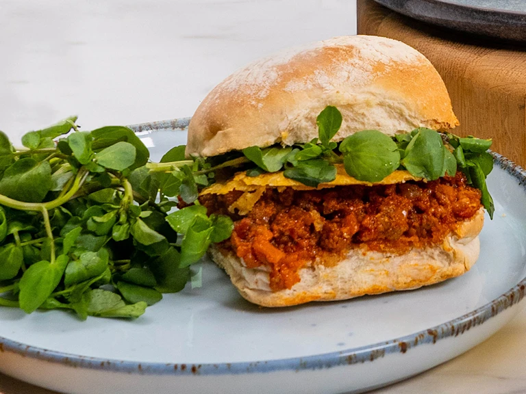 Three Quorn sloppy joes served alongside greens.
