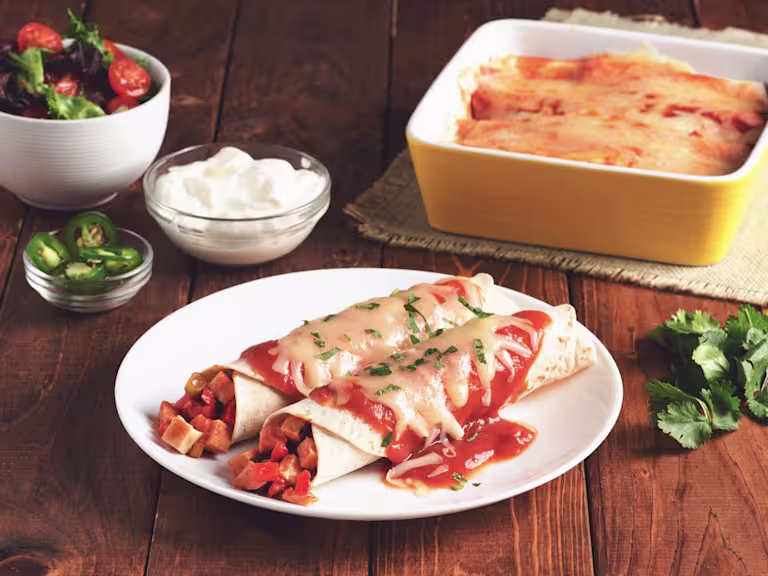 Two enchiladas made with flour tortillas topped with red sauce and cheese filled with Quorn Meatless Vegetarian Turkey Roast.