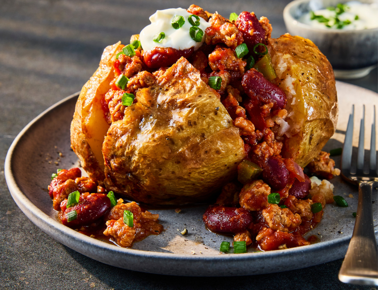 A jacket potato sliced to show the vegetarian chilli made using Quorn Vegetarian Mince. 