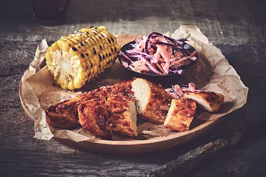 Healthy dinner idea made with Quorn Piri Piri Fillets and homemade slaw and a corn cob, served on baking paper
