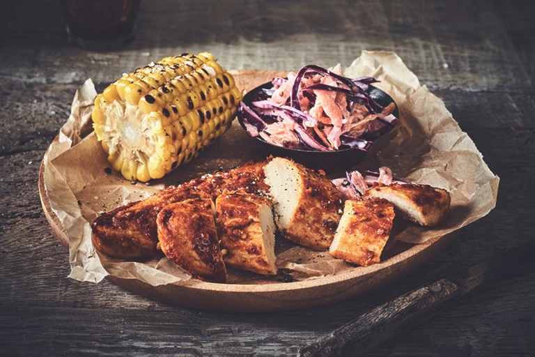 Healthy dinner idea made with Quorn Piri Piri Fillets and homemade slaw and a corn cob, served on baking paper