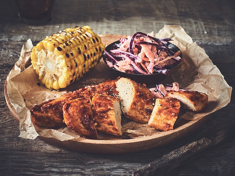 Healthy dinner idea made with Quorn Piri Piri Fillets and homemade slaw and a corn cob, served on baking paper