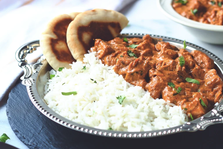 A vegan butter chicken curry made with Quorn Meatless Vegan Pieces served with a side of rice and naan bread.