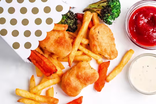 Quorn Crispy Nuggets and fries spilling out of a serving box.