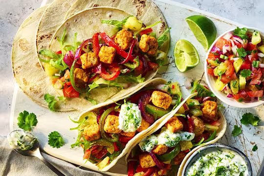 Two Air Fryer Vegetarian Chicken Fajitas and one open to show the filling that includes Quorn Pieces.