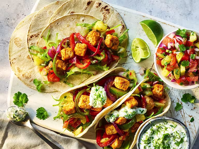 Two Air Fryer Vegetarian Chicken Fajitas and one open to show the filling that includes Quorn Pieces.