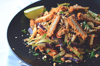 A Thai-inspired salad made with cabbage, carrots, onion, cashews, and cilantro topped with Quorn Vegan Meatless Chipotle Cutlets.