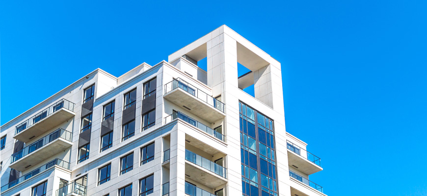 Photo of condos in a big city against a blue background. 