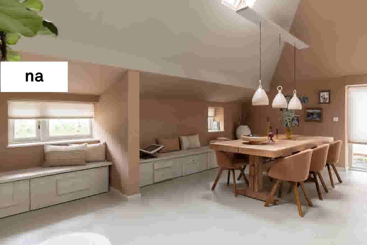 Moderne eetkamer met houten tafel, beige stoelen, witte hanglampen en ingebouwde zitbanken onder schuine wanden.