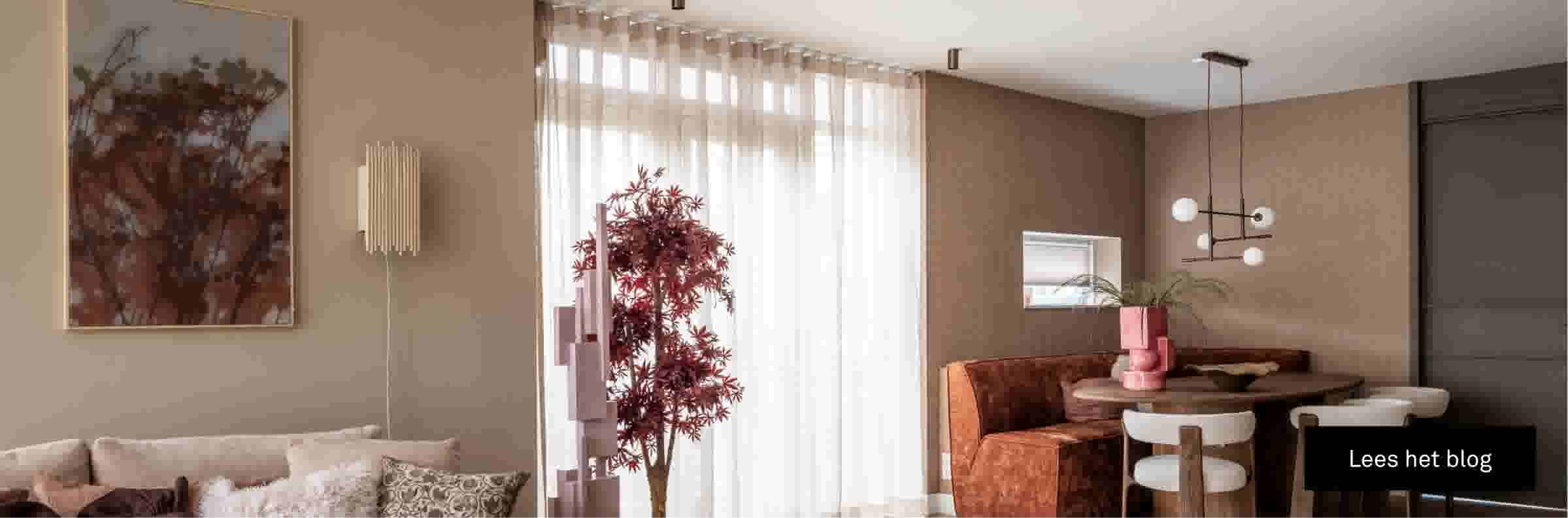 Moderne woonkamer met beige tinten, transparante gordijnen, decoratieve plant en oranje fluwelen bank bij eettafel.