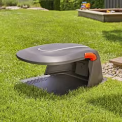 Robotmaaier huisje in een tuin op gras
