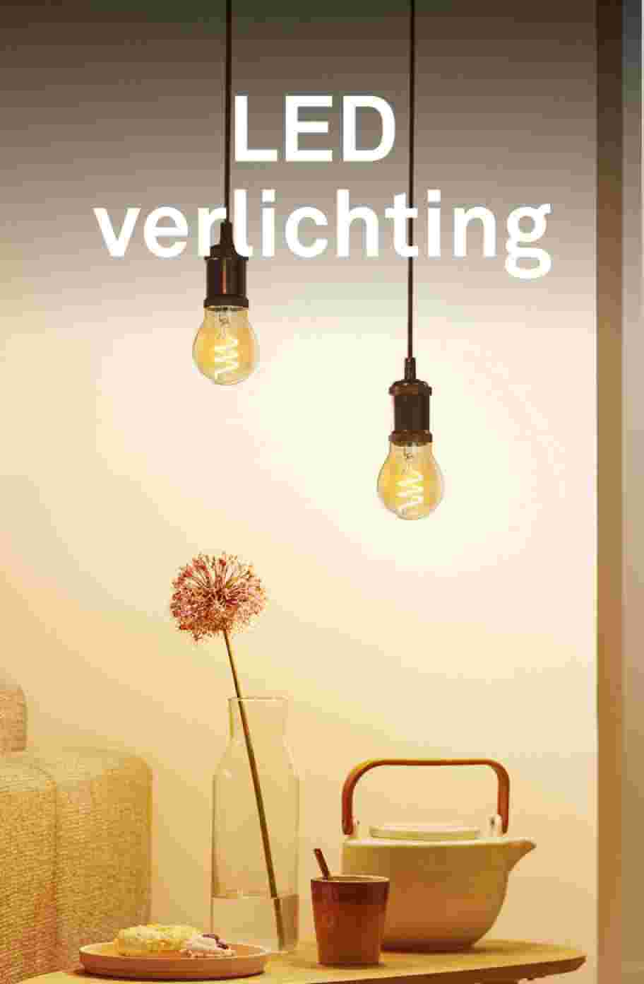Twee LED lampen hangen op verschillende hoogtes boven een tafel met attributen