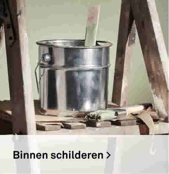 Binnen schilderen. Sfeerbeeld van een verfblik met roerstokje en kwast op een trapladder.