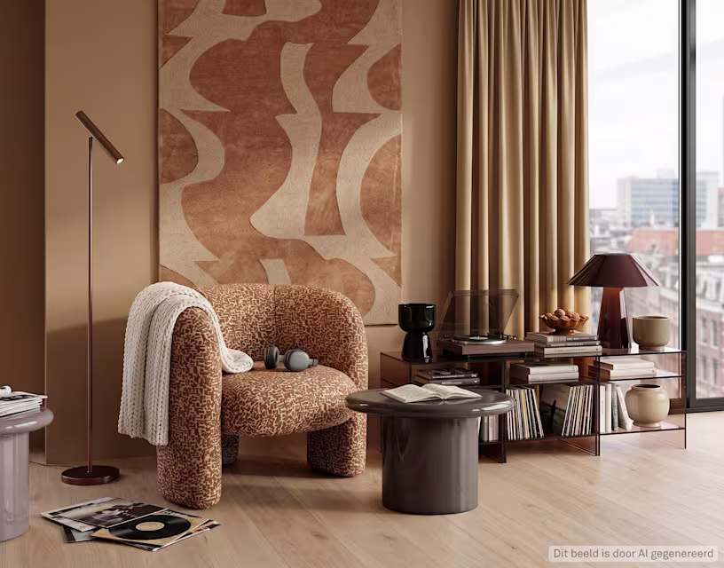 Moderne woonkamer met beige fauteuil, abstract wandtapijt in aardetinten, staande lamp en aan elkaar geschakelde tafeltjes met platenspeler er op.