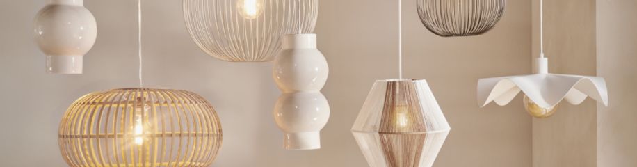 Zeven hangende lampen in verschillende stijlen en materialen, waaronder rotan, metaal en keramiek, in tinten wit en beige.
