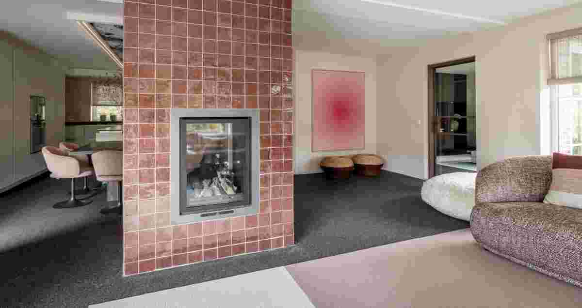 Een betegelde schouw voor een eetkamer met grijze gietvloer. Een muur kleurrijk muur element aan een witte muur. 