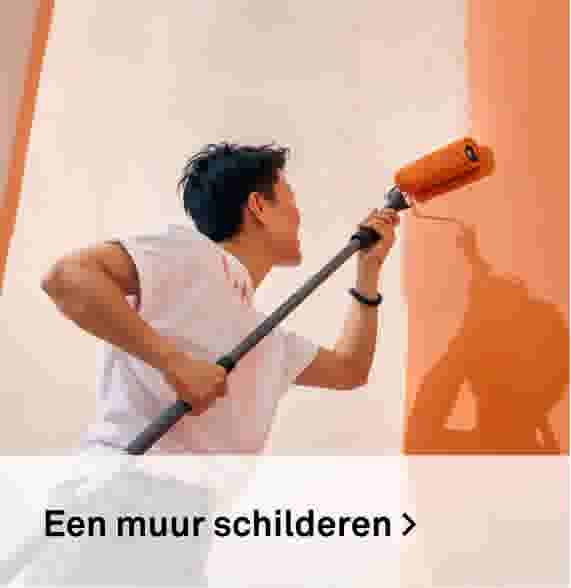 Een muur schilderen. Sfeerbeeld van een man die met een verfroller een oranje muur schildert.