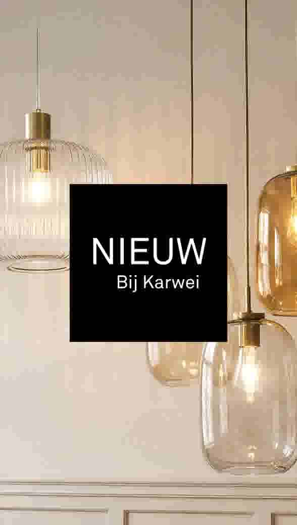 "Nieuw bij Karwei. Sfeerbeeld van hanglampen met glazen kappen in helder en amberkleurig glas met messing details, hangend voor een lichte muur met paneellijsten.