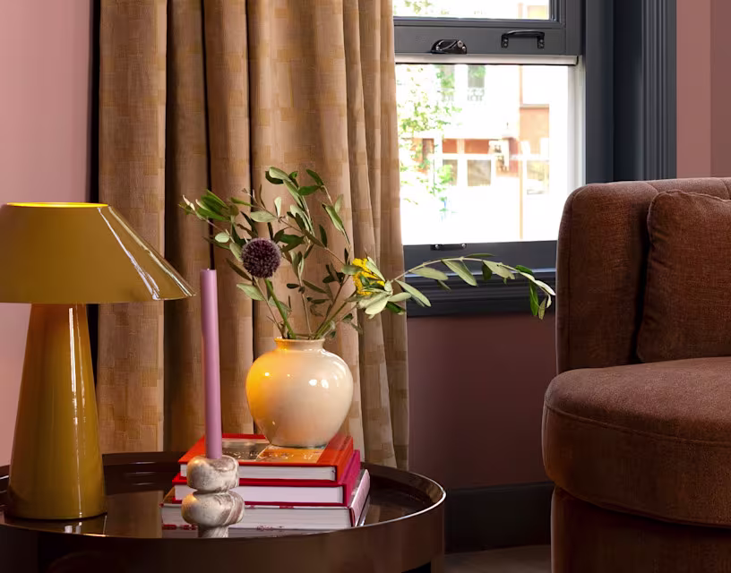 Moderne woonkamer met bruine fauteuil, gele lamp, vaas en beige gordijnen uit de Theo-Bert Pot collectie