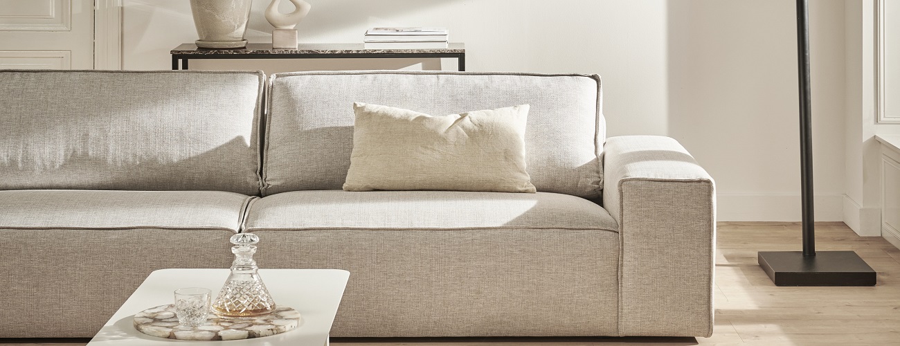 Licht interieur met een beige bank en muur