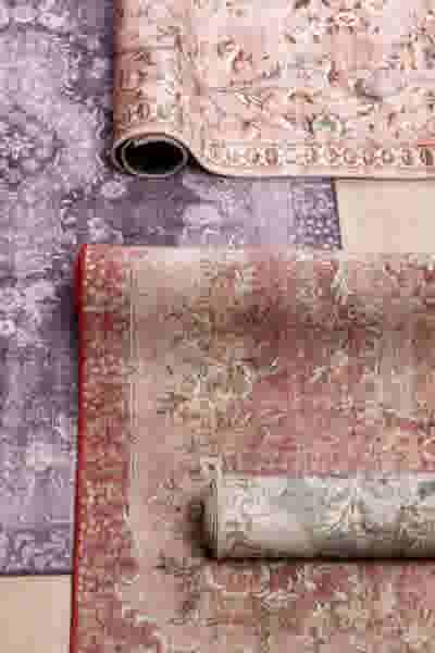 Kamer met lichte vitrages voor de ramen en een ronde tafel met groene stoelen